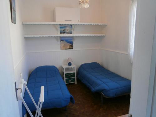 - une chambre avec 2 lits bleus et une étagère dans l'établissement MAMALO, à Biscarrosse