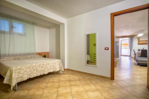 een slaapkamer met een bed en een spiegel bij Villa Lina in Castelsardo