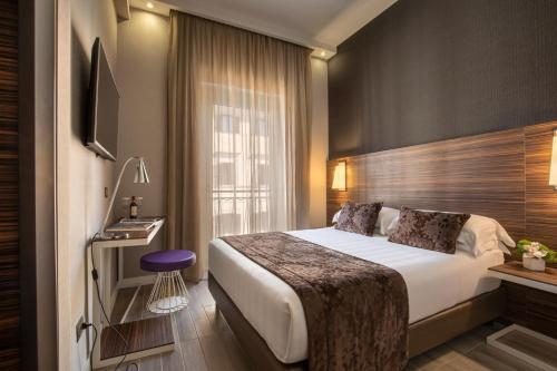 um quarto de hotel com uma cama e uma televisão em The Republic em Roma