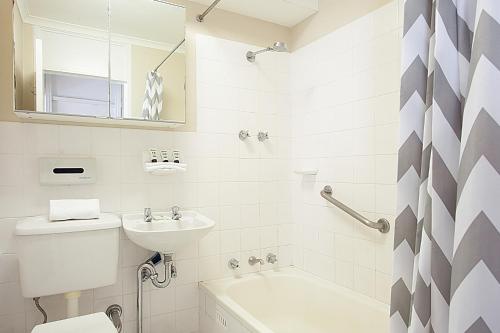 La salle de bains est pourvue d'un lavabo, de toilettes et d'une baignoire. dans l'établissement Harbourside Apartment with Spectacular Pool, à Sydney