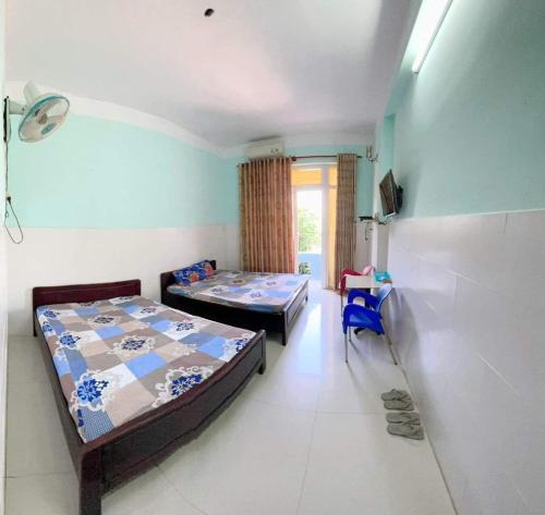 a bedroom with two beds and a chair in it at Nhà nghỉ Vân Châu-Cát Tường in Ấp Chô Bên