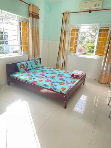 a bedroom with a bed in a room with windows at Nhà nghỉ Vân Châu-Cát Tường in Ấp Chô Bên