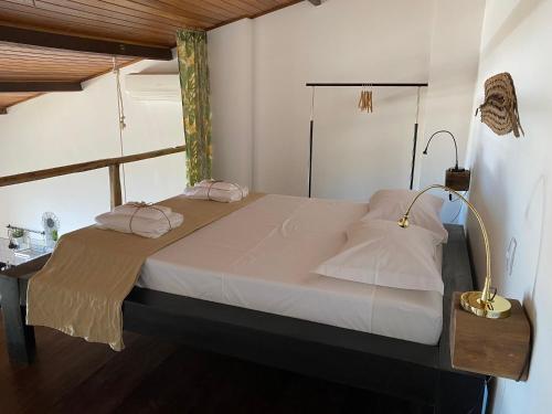 a bedroom with a large bed with two pillows at Casa Versace Salvador - Colonial House in Salvador