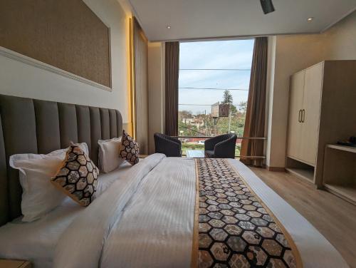 ein Schlafzimmer mit einem großen Bett und einem großen Fenster in der Unterkunft HOTEL CASA ROYALE in Amritsar