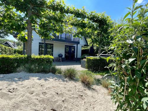 ein Haus am Strand mit einem Baum in der Unterkunft Lovely holiday home in Kaatsheuvel with bubble bath in Kaatsheuvel