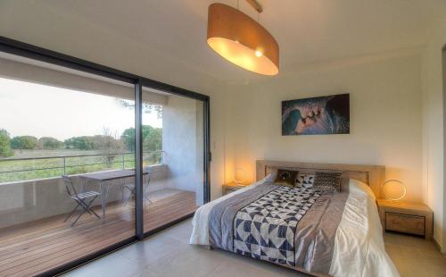 une chambre avec un lit et un balcon dans l'établissement Villa CORSICA SUN, Résidence Cala Rossa Bay, à Lecci