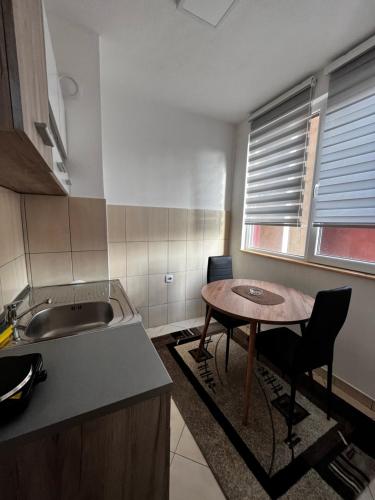 małą kuchnię ze stołem i zlewem w obiekcie Apartman RISTIC w mieście Vranje