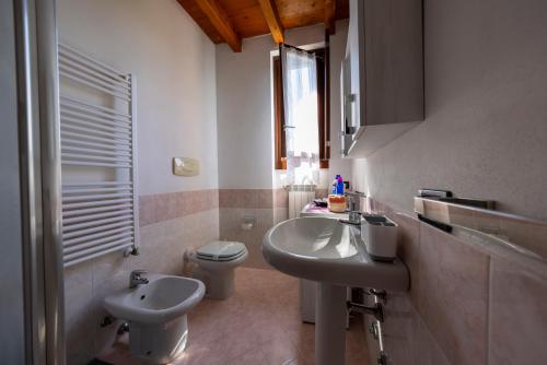 een witte badkamer met een wastafel en een toilet bij Franciacorta Nuvolinis Bike & Maps in Corte Franca