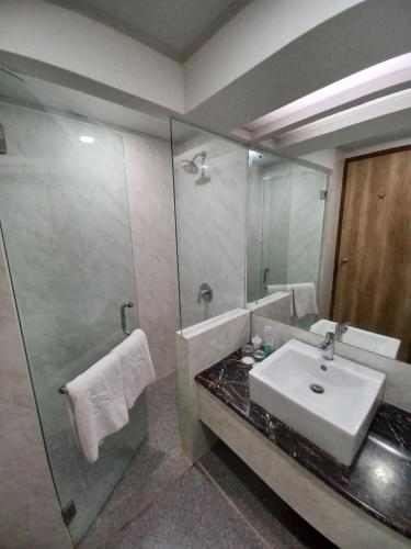 baño con lavabo y espejo grande en Abadi Hotel Malioboro Yogyakarta by Tritama Hospitality en Yogyakarta