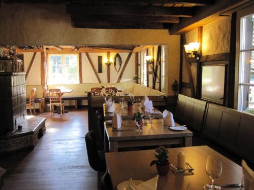 um restaurante com mesas e cadeiras num quarto em Wißkirchen Hotel & Restaurant em Odenthal