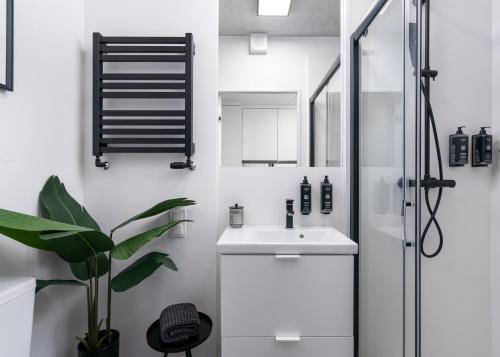een witte badkamer met een wastafel en een douche bij Apartments WrocLOVE by me & Legnicka & Self Check-In 24h & Lift in Wrocław