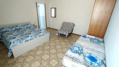 a bedroom with two beds and a chair at Confy Apartments Pompei in Pompei