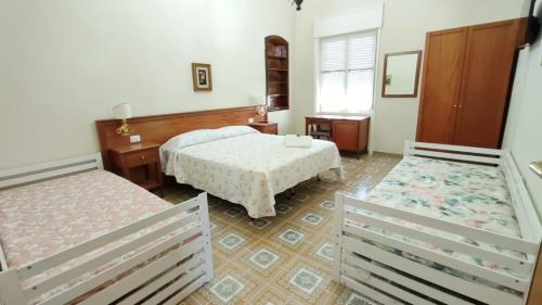 a bedroom with two beds and two chairs in it at Confy Apartments Pompei in Pompei