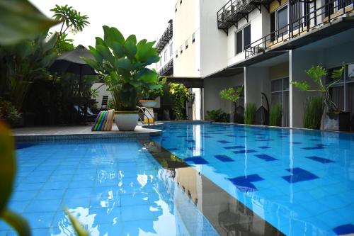 a swimming pool in front of a building at Abadi Hotel Malioboro Yogyakarta by Tritama Hospitality in Yogyakarta