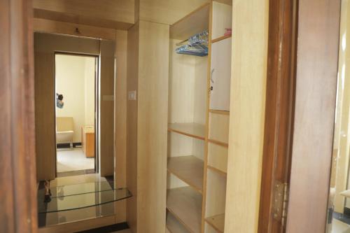 ウダイプールにあるAuthentique Home Abode - 3 Bedroom & Livingの鏡付きのクローゼットとドアが備わる客室です。