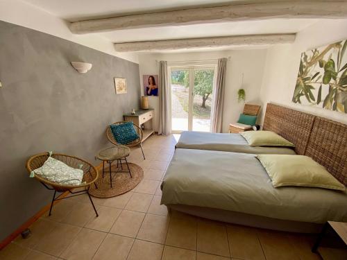 une chambre avec deux lits et une table et des chaises dans l'établissement Pierres-Blanches, à Venasque