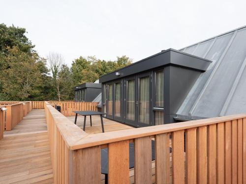 een huis met een zwart dak en een houten terras bij Luxury apartment in Renesse with infrared sauna in Renesse