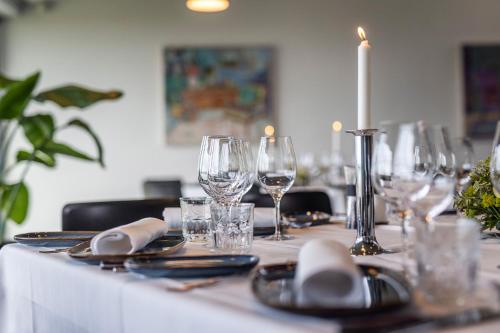 a table with wine glasses and a candle on it at Kobæk Strand Konferencecenter in Skælskør