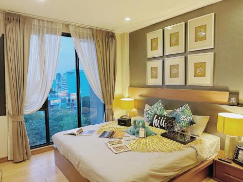 a bedroom with a large bed with a large window at The Astra Condo Changkhlan in Chiang Mai in Chiang Mai