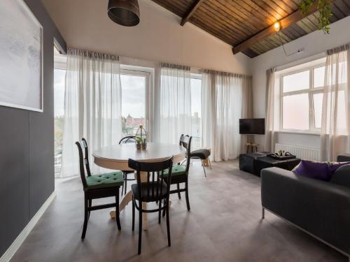 a living room with a table and chairs and a couch at Lovely modern 4 person apartment in the heart of Koudekerke in Koudekerke
