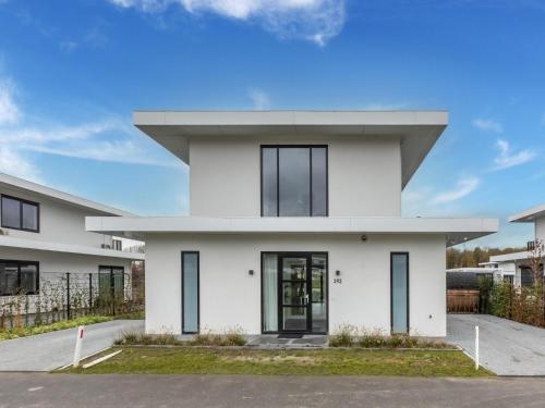 een wit huis met zwarte deuren en ramen bij Brand new luxury villa on a small scale park with its own jetty in Zeewolde
