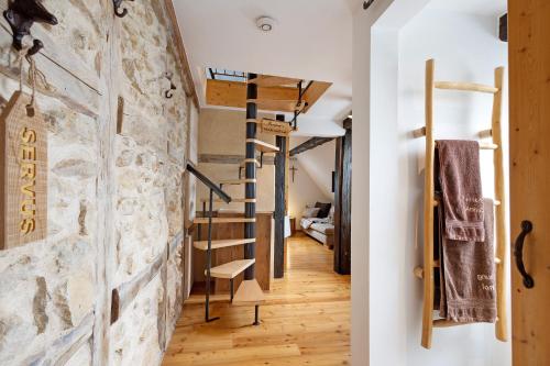 Zimmer mit einer Steinwand und einer Wendeltreppe in der Unterkunft Stub'n Balbine in Waischenfeld