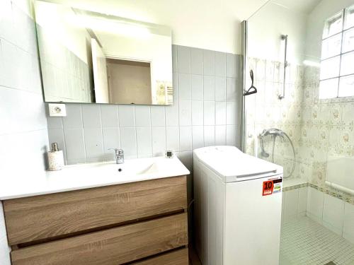 une salle de bain avec un lavabo, des toilettes et un miroir dans l'établissement Authentique Villa Landaise SOUSTONS 7pers., à Soustons