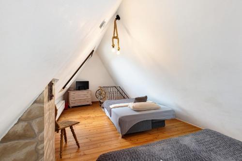a attic bedroom with two beds and a staircase at Stub'n Ludwig in Waischenfeld