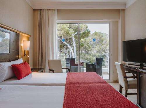 pokój hotelowy z łóżkiem i dużym oknem w obiekcie Grupotel Aguait Resort & Spa - Adults Only w Cala Ratjada