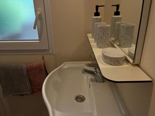 une salle de bain avec un lavabo et un miroir dans l'établissement L’Echappée Belle de Sandra et Nicolas, à Gallargues-le-Montueux