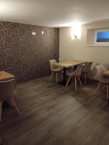 a dining room with tables and chairs and a wall at Berkes Vendégház in Badacsonytördemic