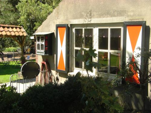 Una casa con rayas anaranjadas y blancas. en Cozy Holiday Home in Bergen op Zoom with Garden, en Bergen op Zoom