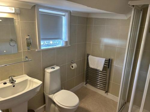 La salle de bains est pourvue de toilettes blanches et d'un lavabo. dans l'établissement Chequers Country Inn, à Lutterworth