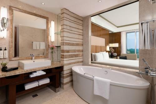 a bathroom with a tub and a sink and a mirror at Crowne Plaza New Delhi Okhla, an IHG Hotel in New Delhi