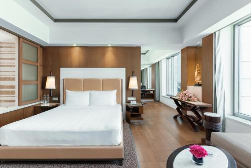 a bedroom with a bed and a living room at Crowne Plaza New Delhi Okhla, an IHG Hotel in New Delhi