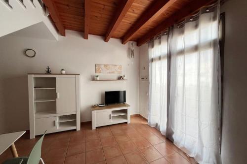 a living room with a television and a window at CASA ALICIA - by 'Fuga A Fuerte' in Cotillo