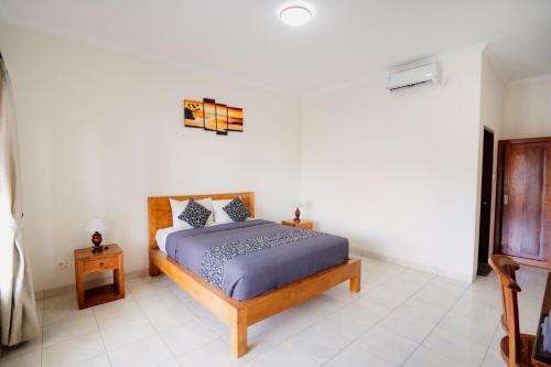 Un dormitorio con una cama en una habitación blanca. en Kayuma Catu Canggu, en Canggu