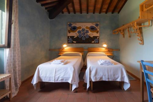 a room with two beds with white tablecloths at Sasseta Alta in Scansano
