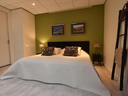 een slaapkamer met een groot bed in een groene muur bij Alluring Apartment in Bergen with Terrace Garden and BBQ in Bergen