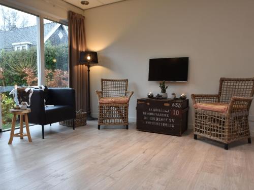 sala de estar con 2 sillas y TV en Alluring Apartment in Bergen with Terrace Garden and BBQ, en Bergen