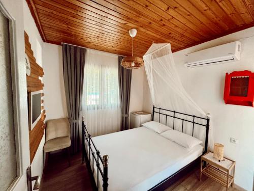 a bedroom with a bed with a wooden ceiling at Cagla Hotel in Ildır