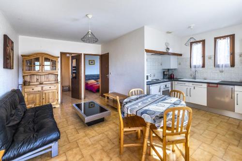 une cuisine et un salon avec une table et un canapé dans l'établissement Mas Jordi - Appt climatisé, à Saint-André