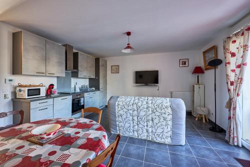 a kitchen and dining room with a table and a kitchen and a dining room at Les Anémones de Langrune - Avec jardin clos in Langrune-sur-Mer