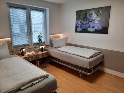 a bedroom with two beds and a table and windows at Ferienwohnung Orient in Liepgarten