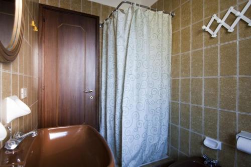 a bathroom with a shower with a sink and a toilet at Appartamenti SA in Follonica