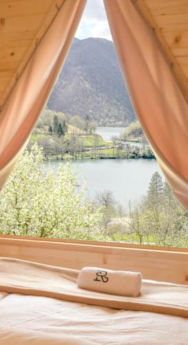 a bedroom with a window with a view of a lake at Cottages Relax in Jajce
