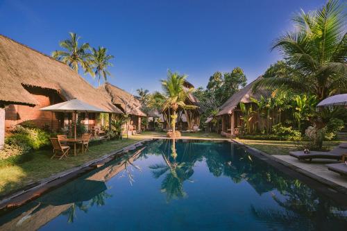 una piscina frente a una villa en De Umah Bali Eco Tradi Home en Bangli