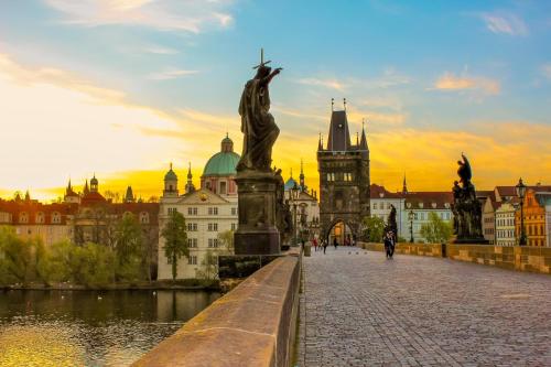 eine Brücke über einen Fluss in einer Stadt mit einer Statue in der Unterkunft New town Prague 5’ walk to Wenceslas Square in Prag