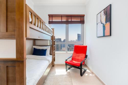een slaapkamer met een stapelbed en een rode stoel bij Incredible Fountain Views 2.5 BR Burj Residences in Dubai