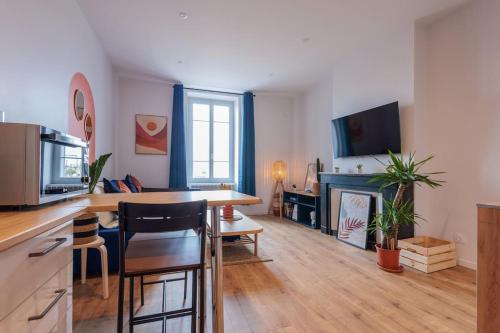 Il dispose d'une cuisine et d'un salon avec une table et une cheminée. dans l'établissement Appart Jean Jaurès - 2 min gare - centre ville, à Bourg-en-Bresse